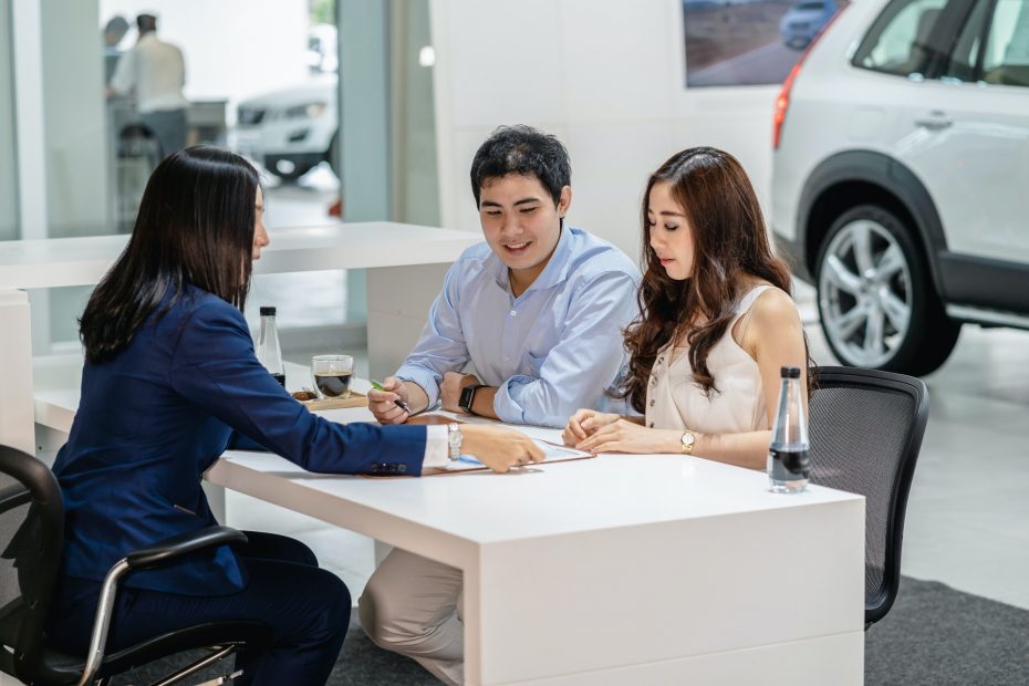 Asian Saleswoman explaining sales contract to couple customer before decision